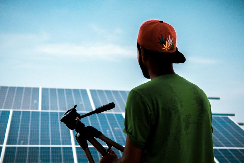 A person in a cap films a solar panel installation, promoting sustainable energy solutions.