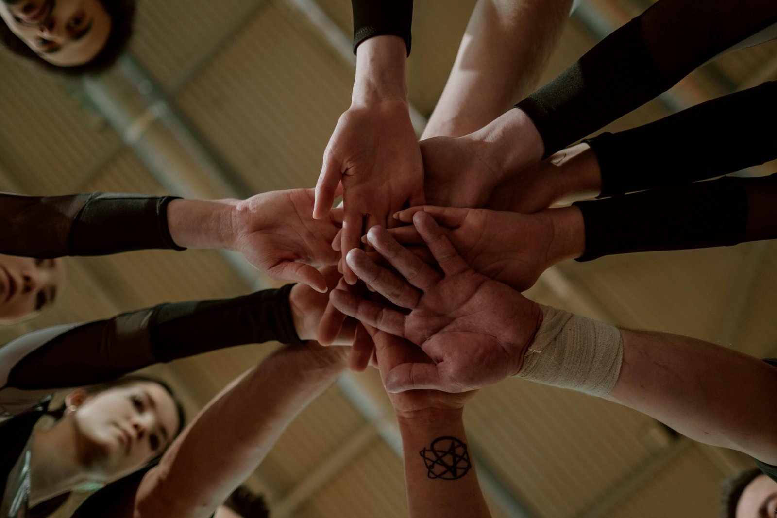 Group of people in a huddle showing unity and teamwork.